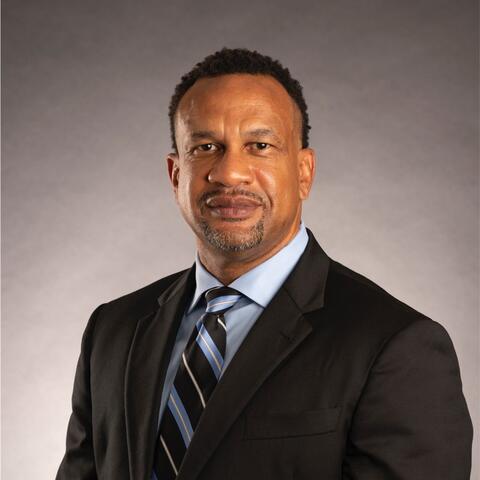 a man smiling wearing a suit